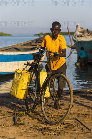 Boy filling water in canisters at Lake Albert