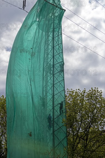 High voltage pylon covered with a tarpaulin due to maintenance work