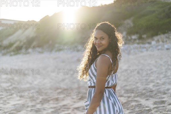 Portrait of a beautiful young woman on the beach by sunset in Algarve