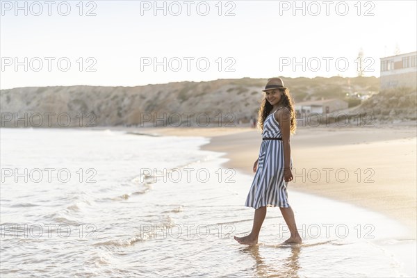 Portrait of a beautiful young woman on the beach by sunset in Algarve