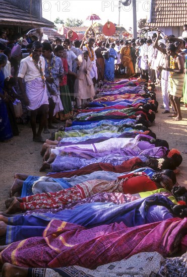 Poojari or priest walking on women in Mahasivaratri festival at poochiyur near Coimbatore