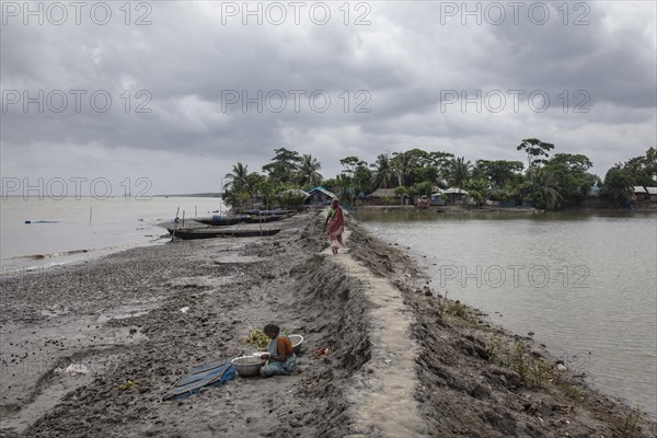 Woman walking on a muddy embankment