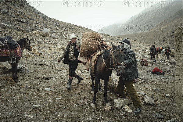 Two men loading a packhorse