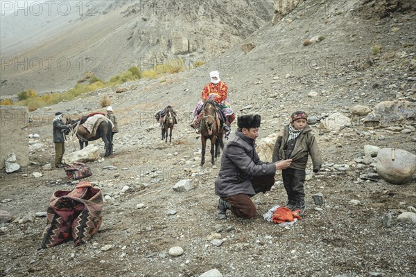 A man puts on a jacket for his son