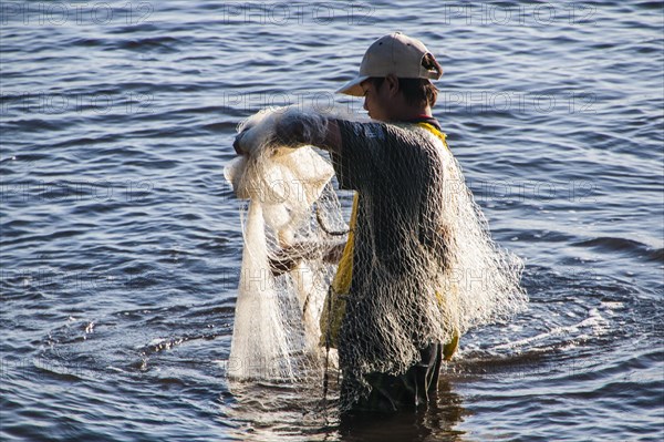 Man netfishing in the harbour of Apia