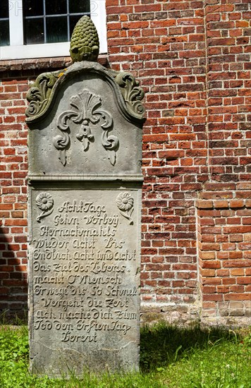 Historic sandstone gravestone from the 18th century in the churchyard of St. Nicholas Church