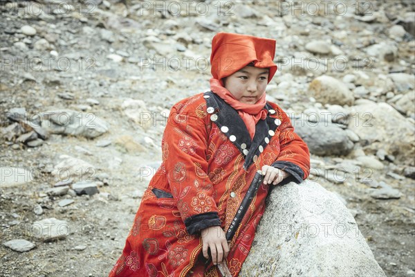 Girl in Kyrgyz traditional costume during the rest of a caravan