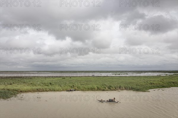 Punt with fisherman on the Poschur River in the Sundarbans