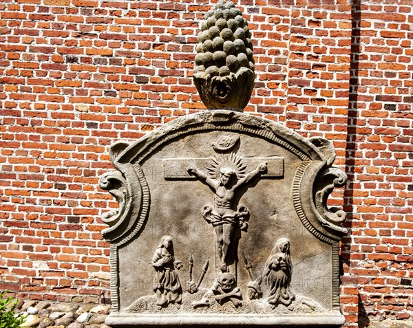 Crucifixion scene on historic sandstone gravestone from the 18th century in the churchyard of St. Nicholas Church