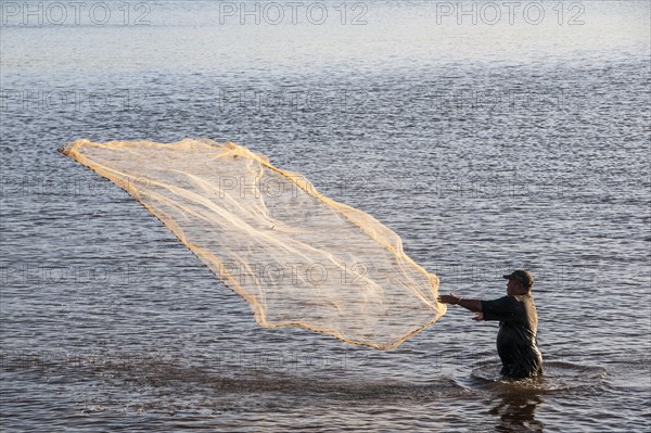 Man netfishing in the harbour of Apia