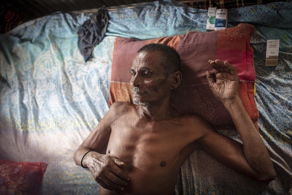 Man on his bed in his hut