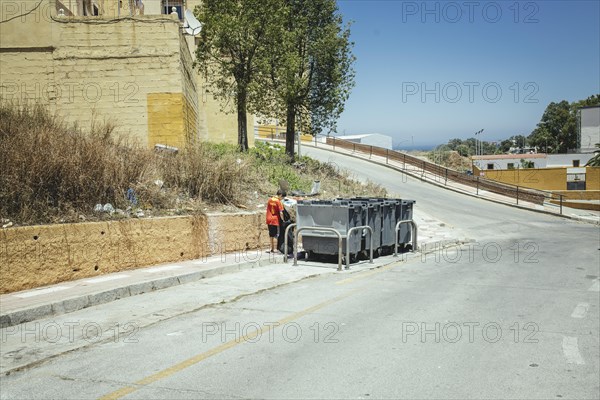 Underage migrant searching in rubbish bins