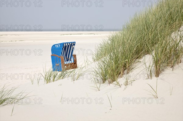 Beach chair with dunes at the beach