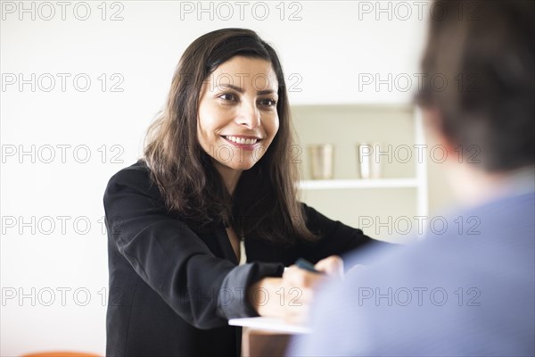 Middle aged serious manager working in an office with client