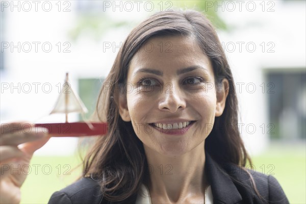 Middle aged serious manager outside with sailing model in hand