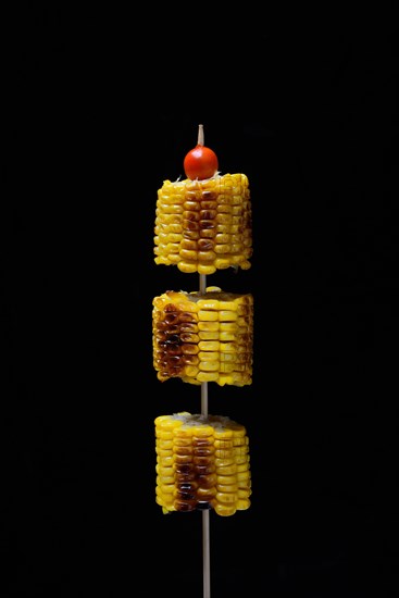 Grilled corn on the corn cob on a skewer