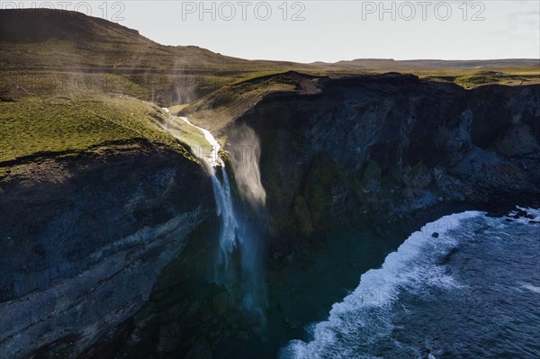 Waterfall at the sea is blown away by wind