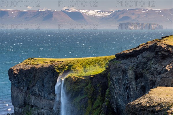 Waterfall falls over cliff and is blown away by wind