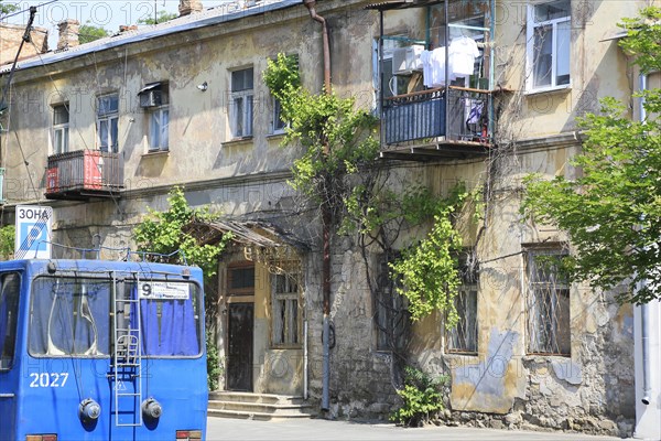 Trolleybus and house facade in need of renovation in Primorski district