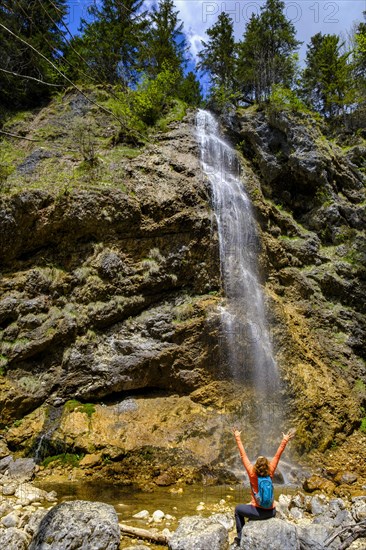 Hiker in front of the Arzmoos waterfall