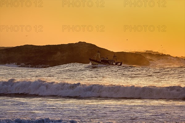 Fishing boat with seagulls in the surf