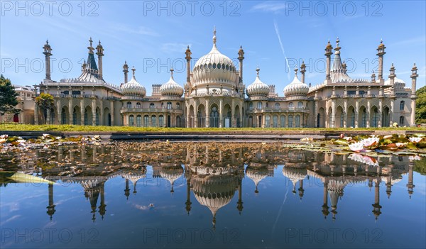 Royal Pavilion palace reflected in a pond with water lilies
