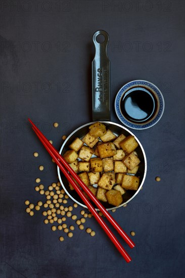 Fried tofu cubes in pan and soy sauce