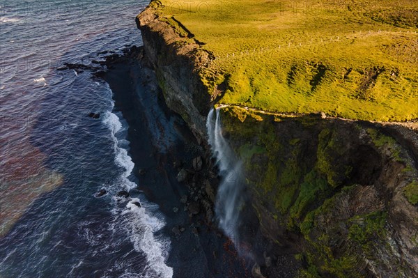 Waterfall at the sea is blown away by wind