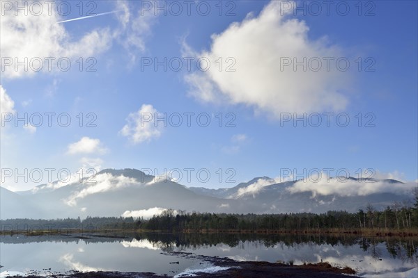 Sky with clouds and condensation trails over moor landscape