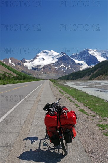 Loaded red touring bike on straight road