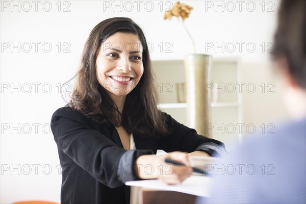 Middle aged serious manager working in an office with client