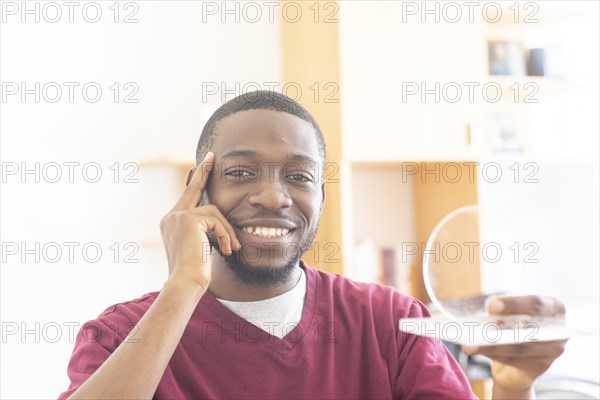 Young black man with sample reconsiders a vision or innovation in the office