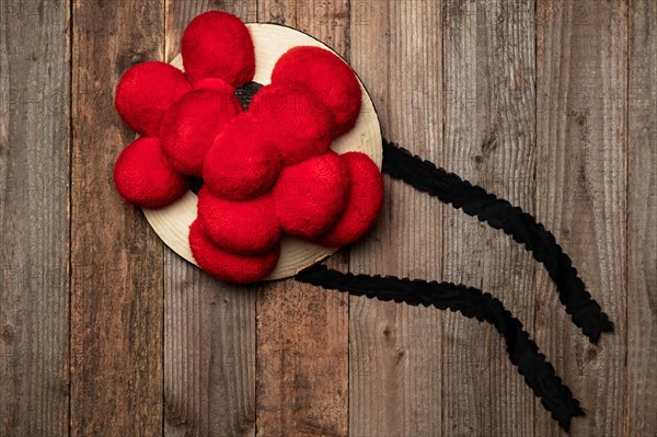 Original Black Forest Bollen hat in front of rustic wooden wall