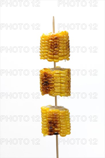 Grilled corn on the corn cob on a skewer