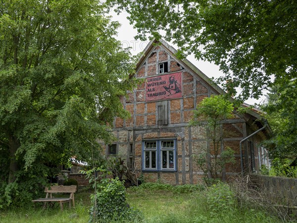 Half-timbered house with banner Lieber wuetend als traurig (Better angry than sad) in the Rundlingsdorf Meuchelfitz