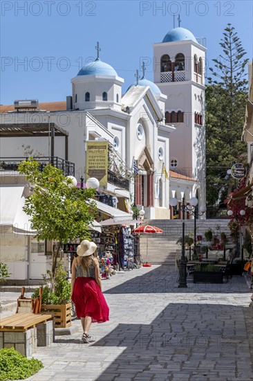 Young woman with dress walking through pedestrian zone