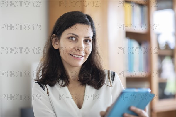 Middle aged serious manager working in an office with tablet