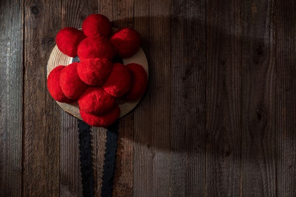 Original Black Forest Bollen hat in front of rustic wooden wall