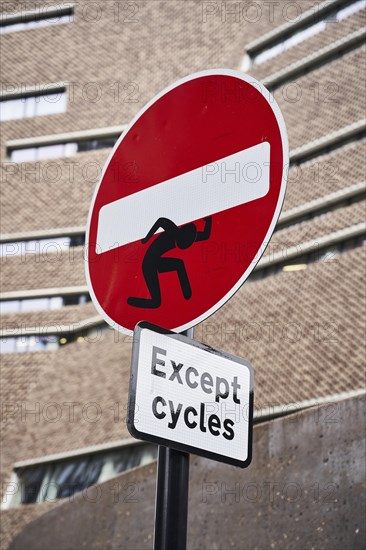 One-way street sign with street art manikin