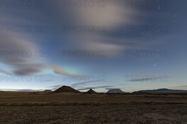 Faint northern lights (Aurora Borealis) and star trails