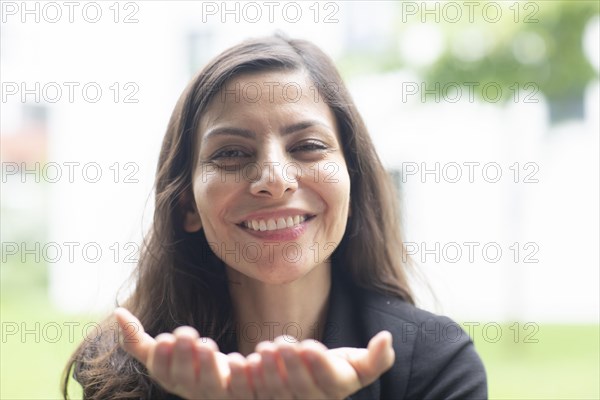 Middle aged serious manager laughing outside with open hands