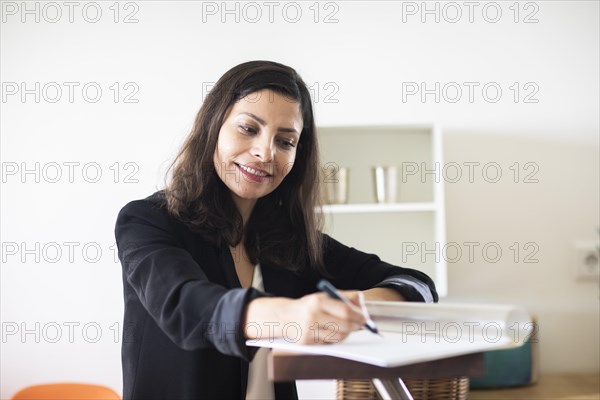 Middle aged serious manager working in an office with portfolio
