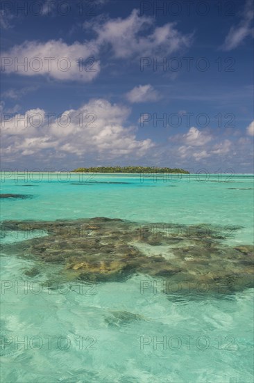 Little island in the turquoise waters in the Aitutaki lagoon