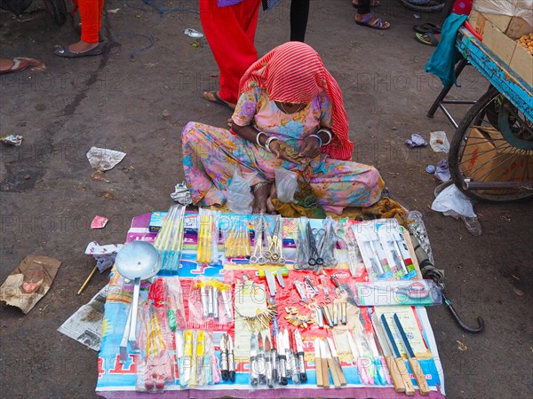 Vendor offering household appliances at market stall