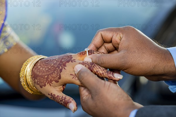 Engagement ring ceremony of a Mauritian Hindu couple. Groom passing ring in his bride`s finger