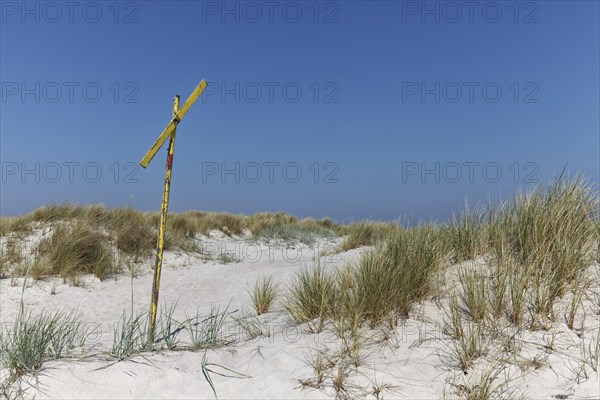 Weathered warning sign of shoals near the shore