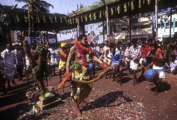 A god possessed man beating himself with whip. Mariamman festival at Coimbatore