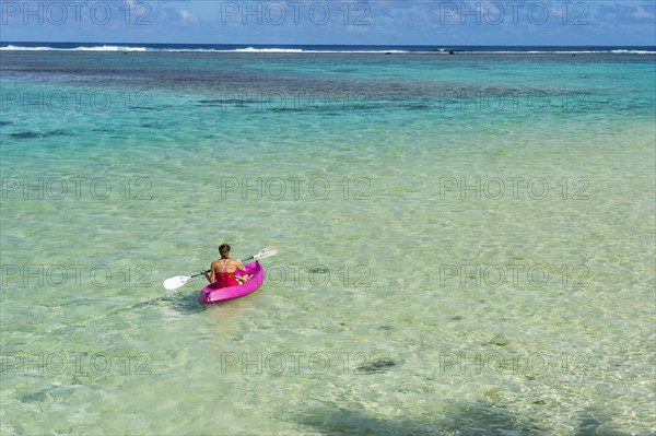 Woman kayaking in the turquoise waters of Rarotonga