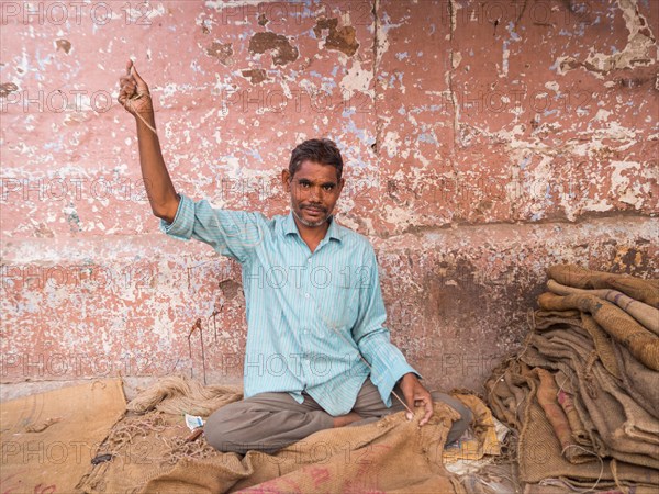 Worker sewing sacks