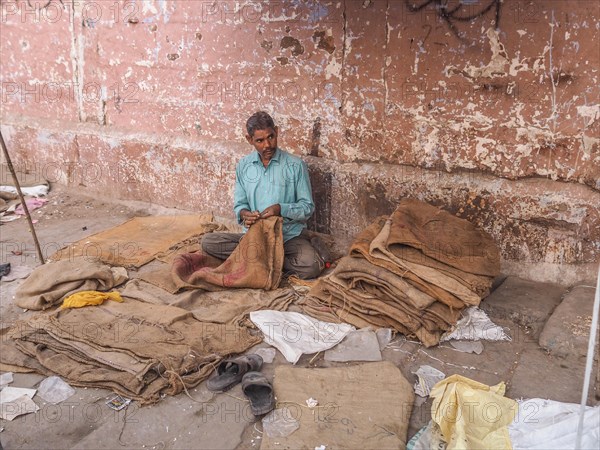 Worker sewing sacks